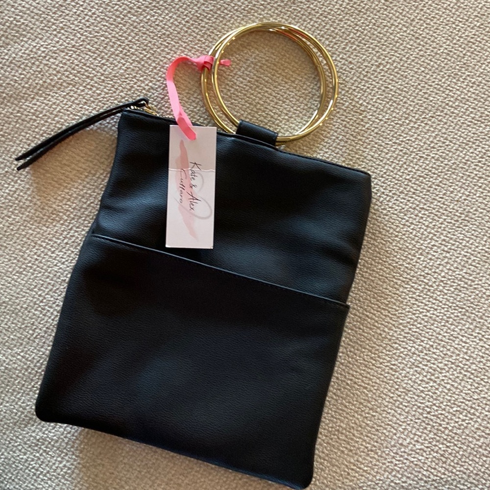 La Diva black handbag with 2 gold ring handles. Zip top. 3 pockets inside